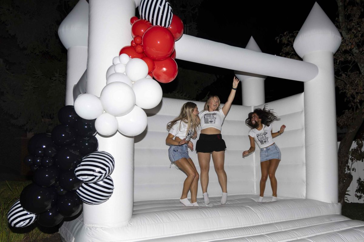 New members of Delta Zeta jump on a bouncy castle after arriving at their new house during bid day on Monday, Sept. 9, 2024, at Greek Row in Lexington, Kentucky. Photo by Matthew Mueller | Staff