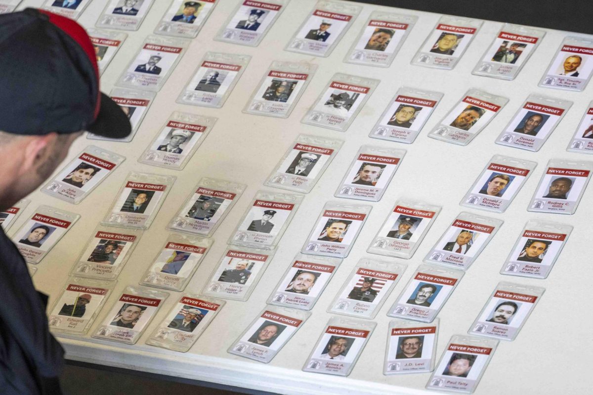 A participant looks over badges with those who died during the attacks on 9/11 during the 9/11 Memorial Stair Climb on Wednesday, Sept. 11, 2024, at Kroger Field in Lexington, Kentucky. Photo by Matthew Mueller | Staff