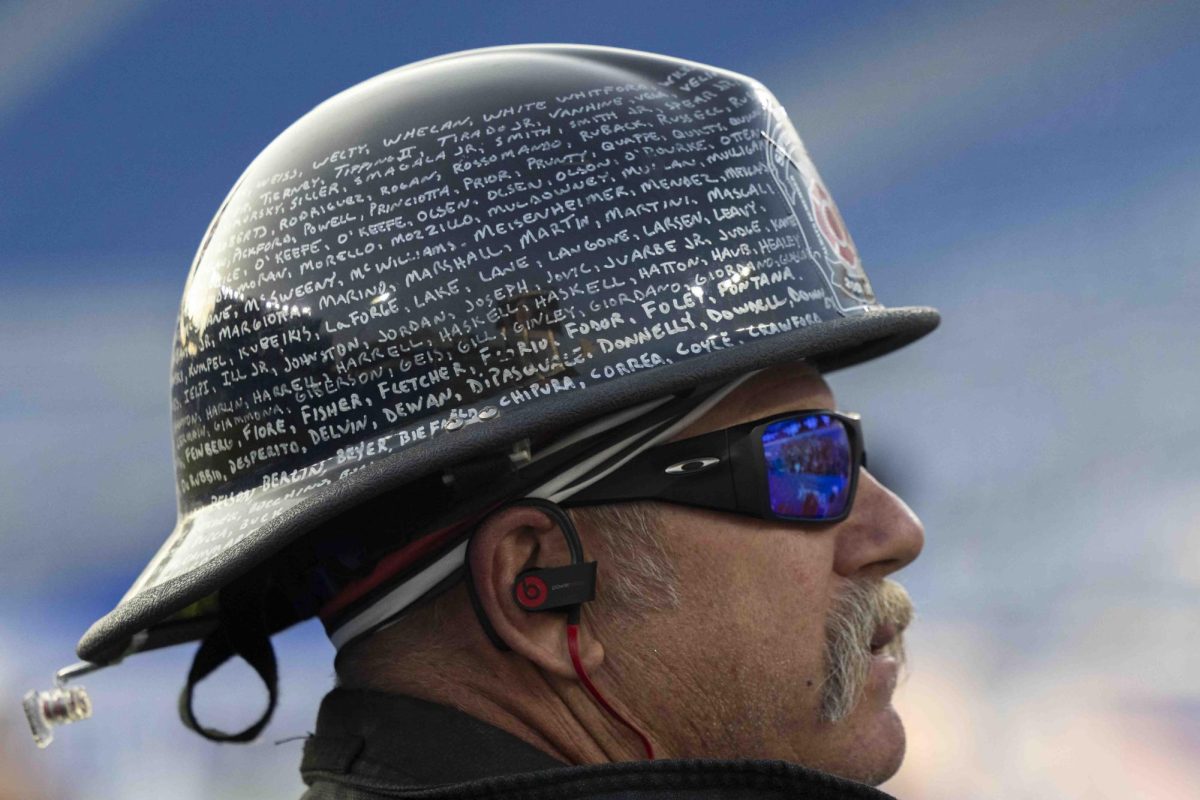 A firefighter wears a helmet with 9/11 victim names written on it during the 9/11 Memorial Stair Climb on Wednesday, Sept. 11, 2024, at Kroger Field in Lexington, Kentucky. Photo by Matthew Mueller | Staff