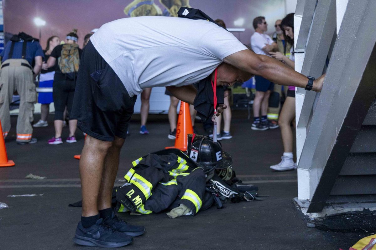 Arthur Lucas, 40, stretches before the beginning of the 9/11 Memorial Stair Climb on Wednesday, Sept. 11, 2024, at Kroger Field in Lexington, Kentucky. Photo by Matthew Mueller | Staff