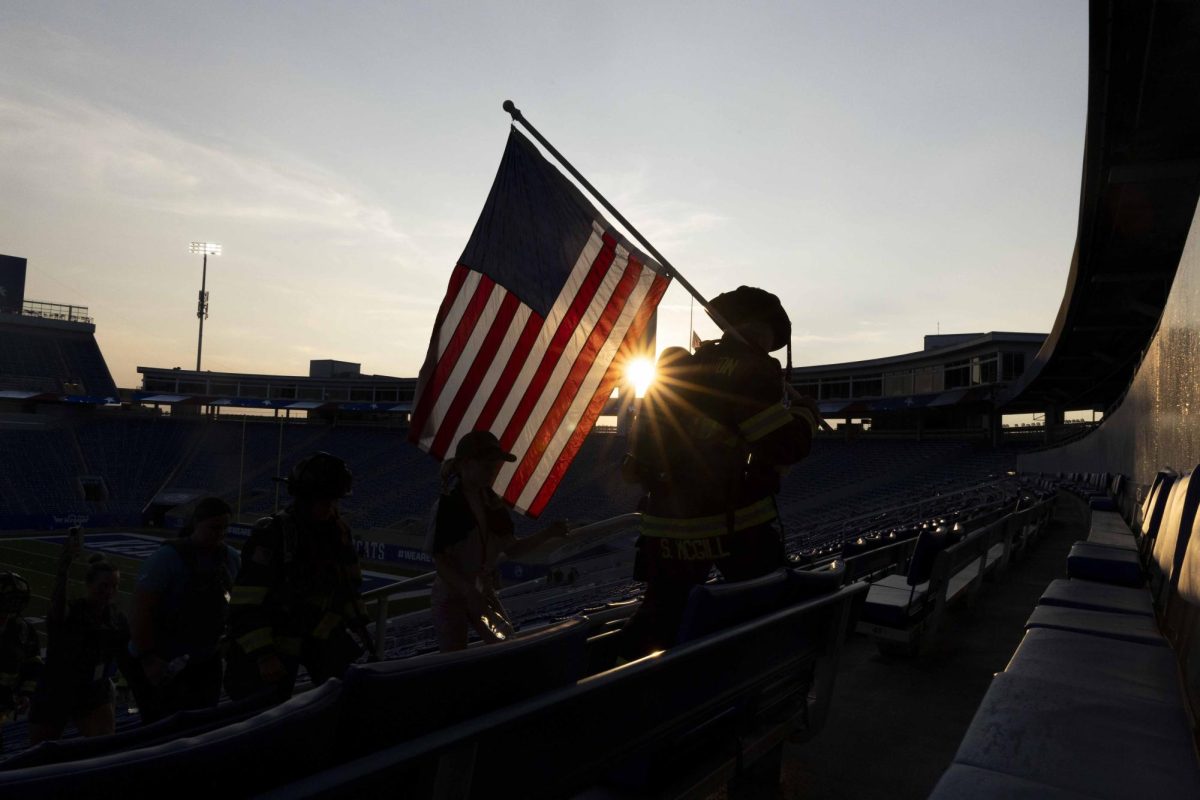 Firefighter Sara McGill carries an American flag during the 9/11 Memorial Stair Climb on Wednesday, Sept. 11, 2024, at Kroger Field in Lexington, Kentucky. Photo by Matthew Mueller | Staff