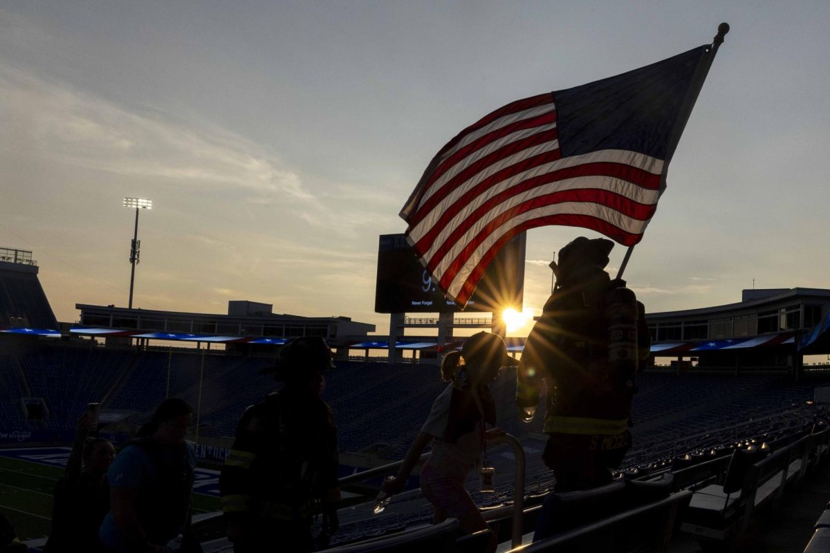 Firefighter Sara McGill carries an American flag during the 9/11 Memorial Stair Climb on Wednesday, Sept. 11, 2024, at Kroger Field in Lexington, Kentucky. Photo by Matthew Mueller | Staff