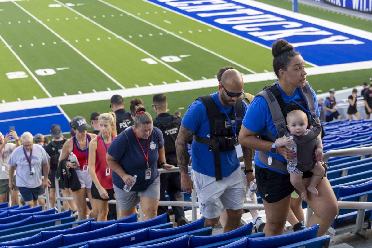 A mother carries her child during the 9/11 Memorial Stair Climb on Wednesday, Sept. 11, 2024, at Kroger Field in Lexington, Kentucky. Photo by Matthew Mueller | Staff