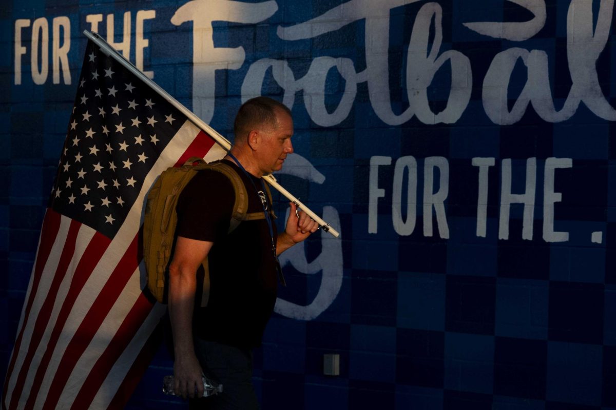 A community member carries an American flag during the 9/11 Memorial Stair Climb on Wednesday, Sept. 11, 2024, at Kroger Field in Lexington, Kentucky. Photo by Matthew Mueller | Staff