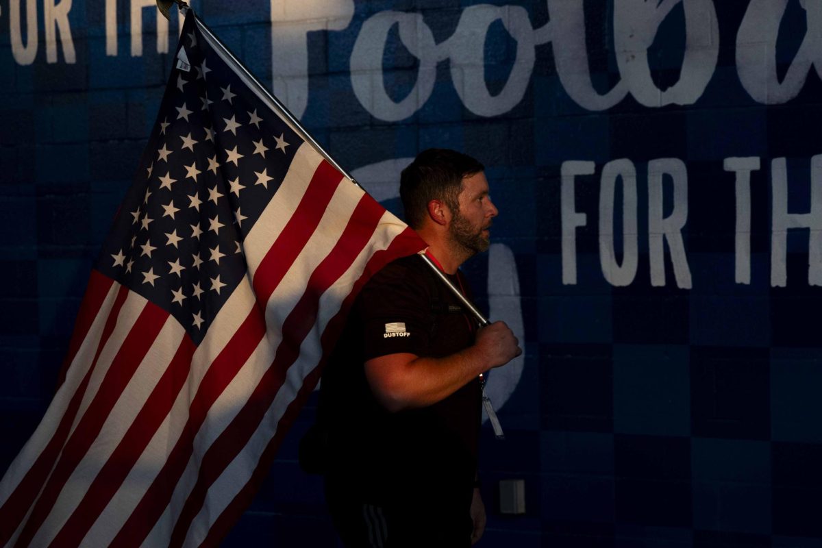 A community member carries an American flag during the 9/11 Memorial Stair Climb on Wednesday, Sept. 11, 2024, at Kroger Field in Lexington, Kentucky. Photo by Matthew Mueller | Staff