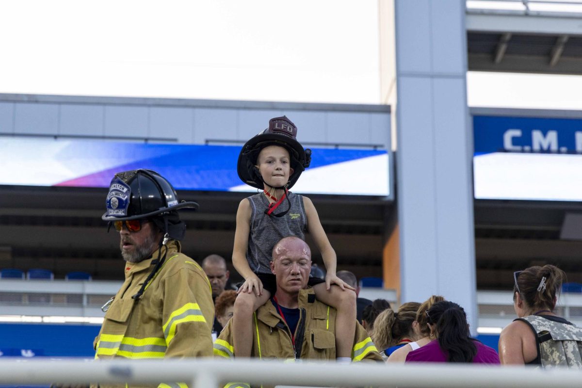 A firefighter carries his son on his shoulders during the 9/11 Memorial Stair Climb on Wednesday, Sept. 11, 2024, at Kroger Field in Lexington, Kentucky. Photo by Matthew Mueller | Staff