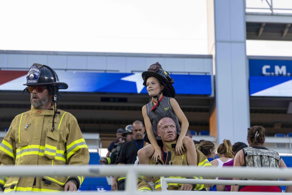 A firefighter carries his son on his shoulders during the 9/11 Memorial Stair Climb on Wednesday, Sept. 11, 2024, at Kroger Field in Lexington, Kentucky. Photo by Matthew Mueller | Staff