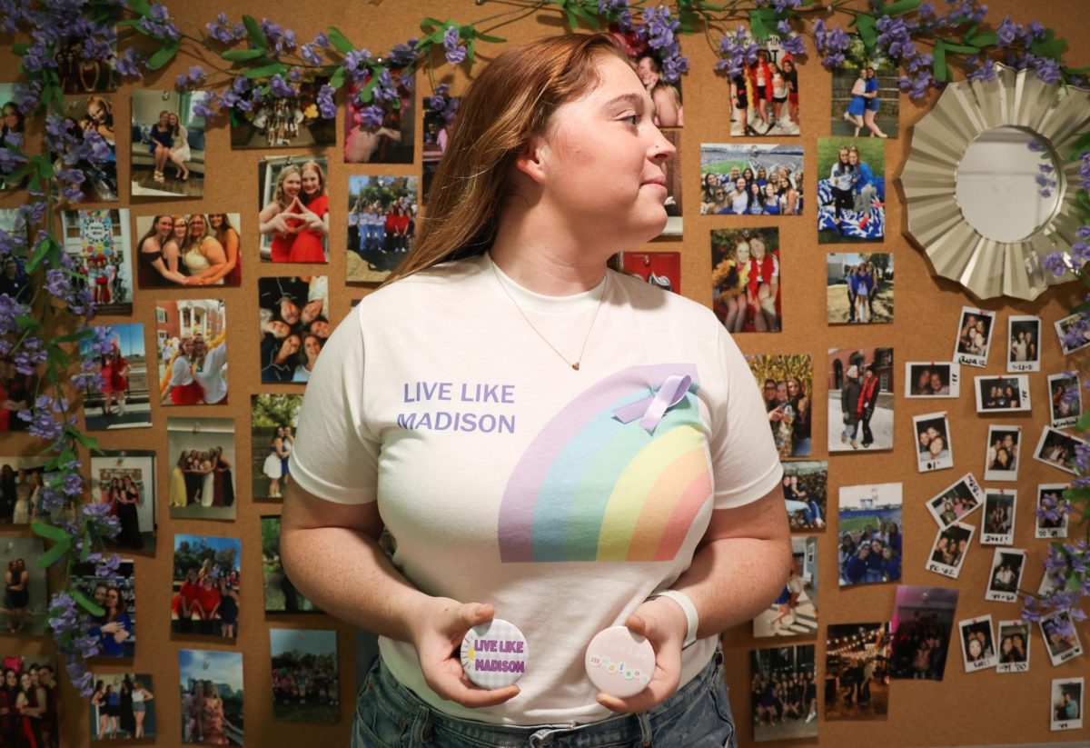 Paige Temple holds “Live like Madison” buttons on Wednesday, Sept. 25, 2024, at the Alpha Gamma Delta sorority house at the University of Kentucky in Lexington, Kentucky. The buttons honor the memory of Madison Becknell, a UK student who died three months before her graduation. Photo by Abbey Cutrer | Staff