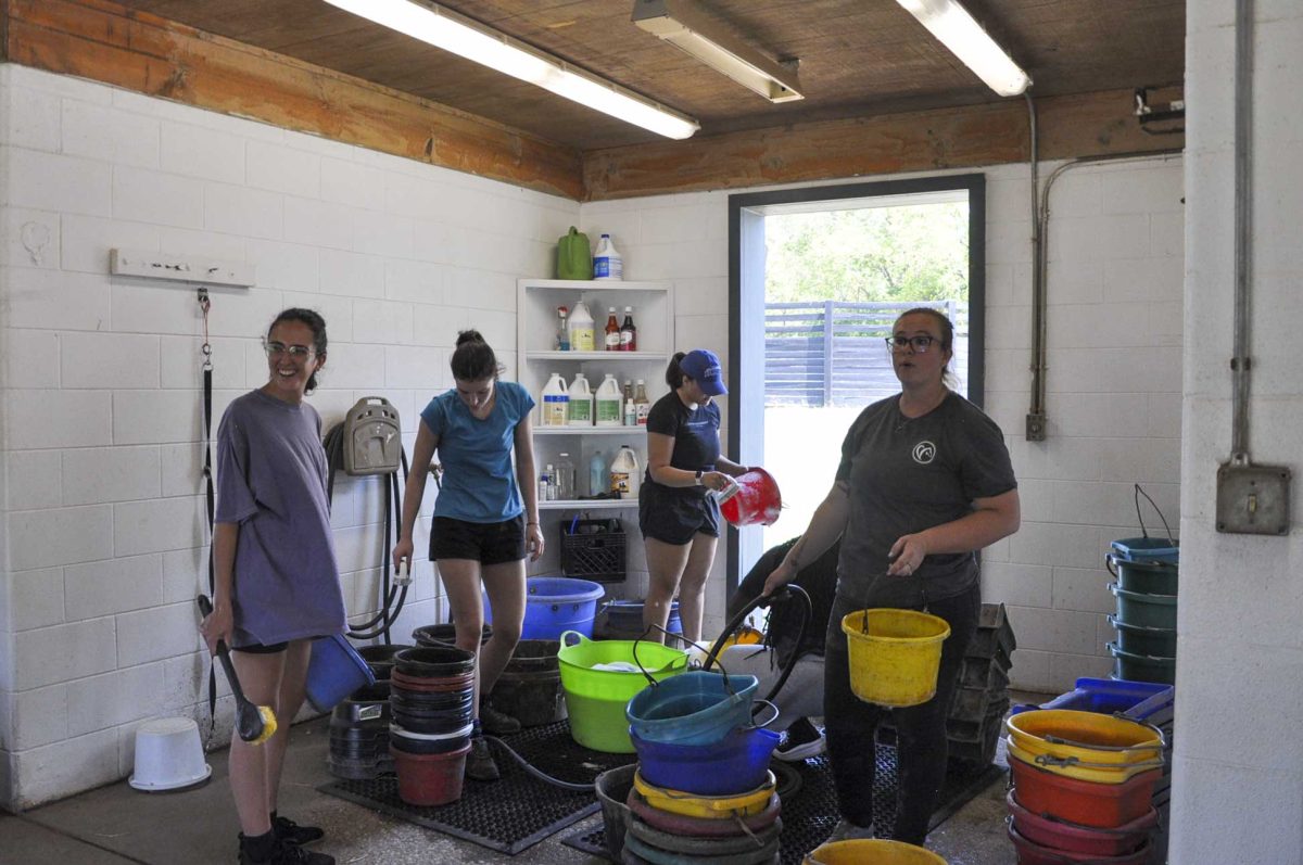 Students clean buckets used to feed the horses on Saturday, Aug. 31, 2024, at the Secretariat Center in Lexington, Kentucky. Photo by Isabella Sepahban | Staff