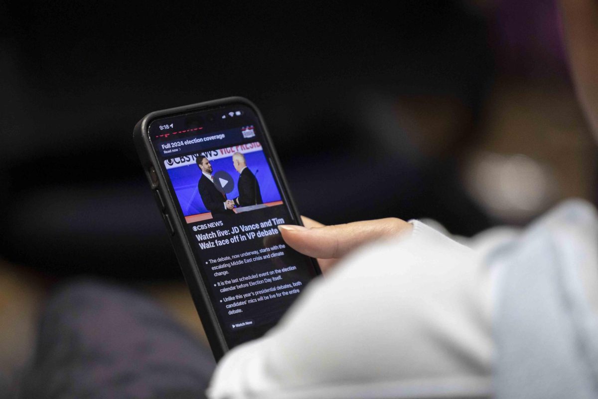 A student opens her phone to news about the debate on Tuesday, Oct. 1, 2024, at Lewis Honors  College in Lexington, Kentucky. Photo by Matthew Mueller | Staff 