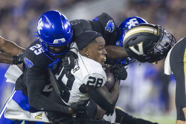 Kentucky Wildcats defensive back Jordan Lovett (25) tackles Vanderbilt Commodores Quarterback Thomas Jones (28) during the football game vs. Vanderbilt on Saturday, Oct. 12, 2024, at Kroger Field in Lexington, Kentucky. Photo by Matthew Mueller | Staff