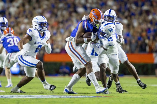 Kentucky Wildcats defensive back Jordan Lovett (25) tackles Florida Gators Tight End Arlis Boardingham during the football game vs Florida on Saturday, Oct. 19, 2024, at Ben Hill Griffin Stadium in Gainesville, Florida. Photo by Matthew Mueller | Staff