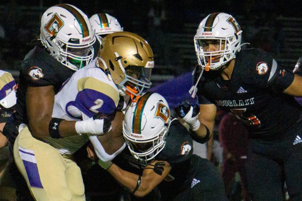 Male High School running back DJ Ginter (2) pushes through defenders during the game vs. Frederick Douglass High School on Friday, Oct. 5, 2024, at Frederick Douglass High School in Lexington, KY. Male won 31-28.