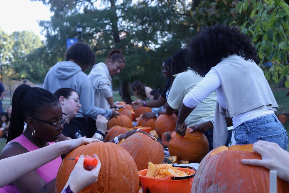 Students carve pumpkins outside of Champions Kitchen at "Big Boo Bash" on Oct. 23, 2024 at the University of Kentucky in Lexington, Kentucky.