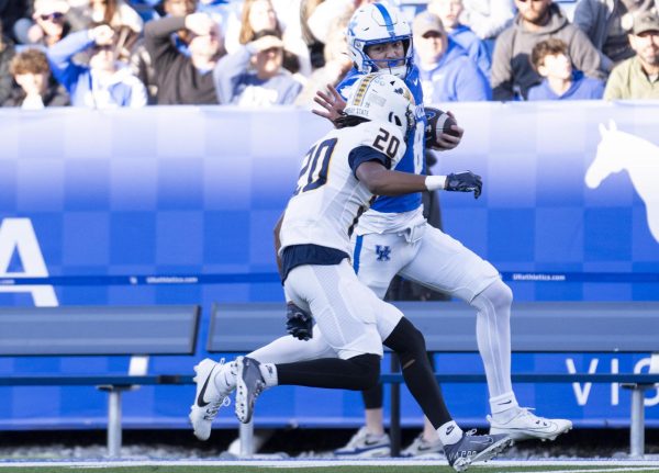 Kentucky Wildcats quarterback Cutter Boley (8) scores a touchdown while holding off Murray State defensive back Chavaris Dumas (20) during the Kentucky vs. Murray State football game on Saturday, Nov. 16, 2024, at Kroger Field in Lexington, Kentucky. Kentucky won 48-6. Photo by Christian Kantosky | Staff