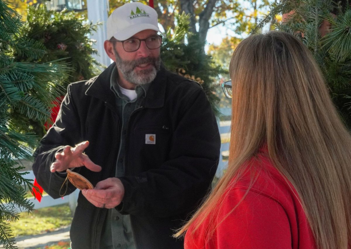 David Yount helps customers choose out ornaments from Sherwood Acres' offerings at Shaker Village's Christmas Market on Nov. 16, 2024, in Harrodsburg, Kentucky. Photo by Hannah Piedad | Staff