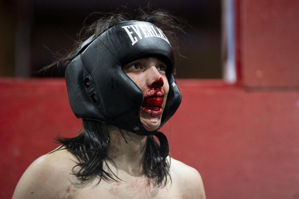 Adam Wellens listens to the match official while blood runs down his mouth during the UK Boxing Club exhibition match on Saturday, Nov. 23, 2024, at Thrive Tribe Boxing and Fitness in Lexington, Kentucky. Photo by Christian Kantosky | Assistant Photo Editor