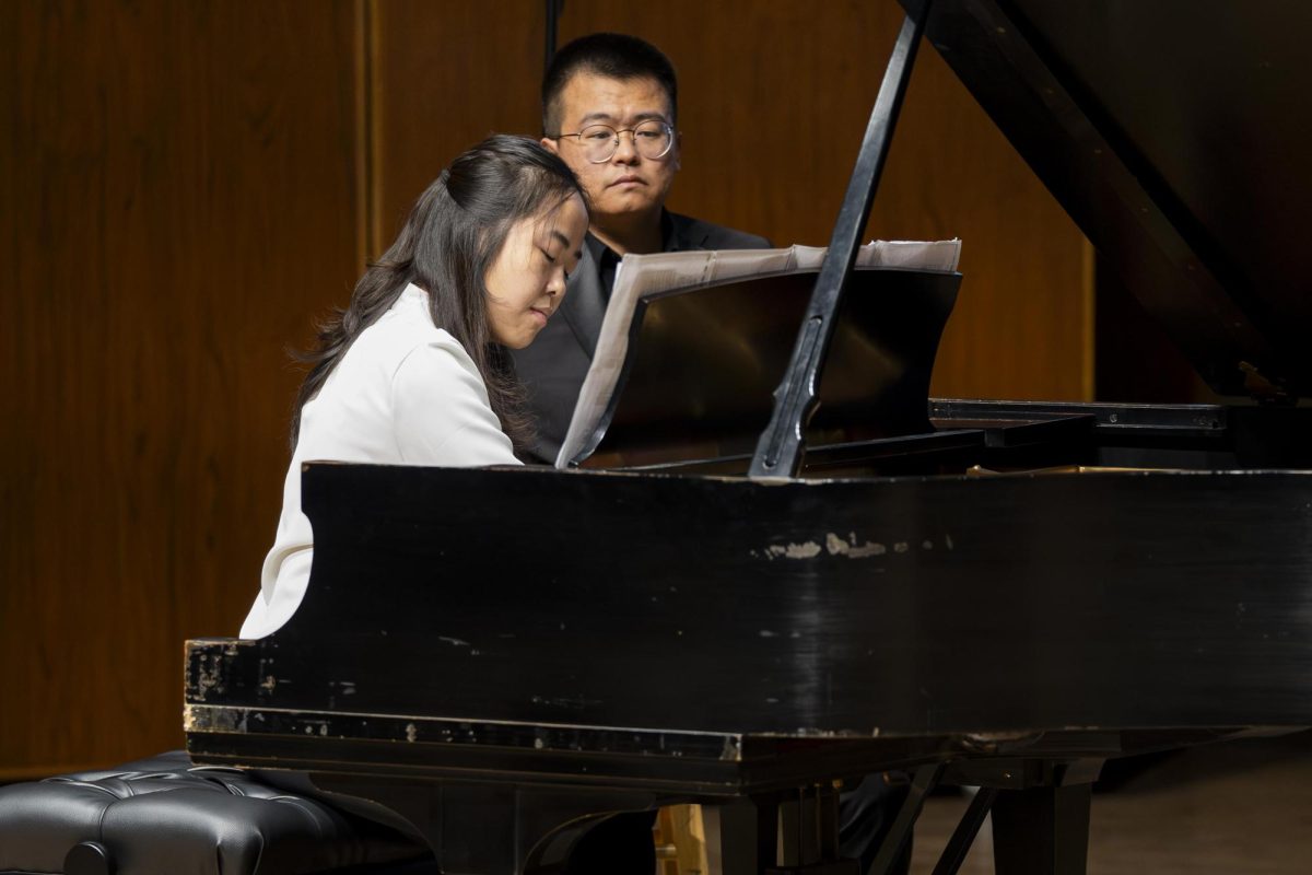 Jiayu Teng performs "Winnsboro Cotton Mill Blues" by Frederic Rzewski while Cody Kuriwa turns pages during the Piano Studio Concert on Monday, Nov. 25, 2024, at the Singletary Center for the Arts in Lexington, Kentucky. Photo by Christian Kantosky | Assistant Photo Editor