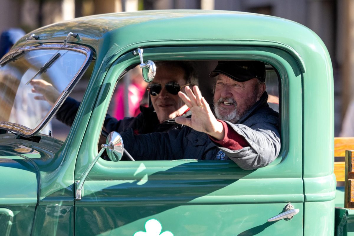 A parade participant waves at bystanders during the Lexington Holiday parade on Saturday, Dec. 7, 2024, at Main Street in Lexington, Kentucky. Photo by Sydney Yonker | Staff