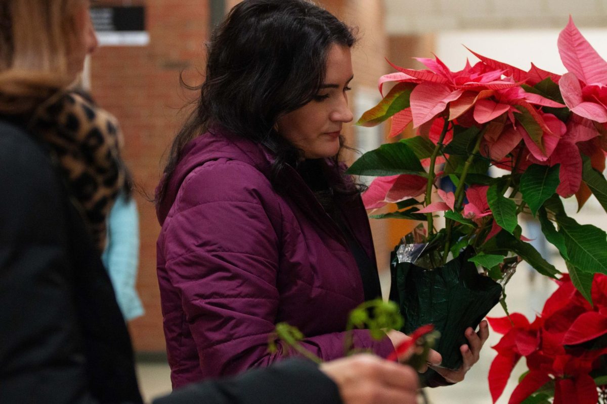 Callie Brown, a graduate student, purchases a poinsettias during the Horticulture Club Winter Sale on Dec. 11, 2024 at the Agriculture North Building Lobby, in Lexington, Kentucky. Photo by Hannah Piedad | Staff