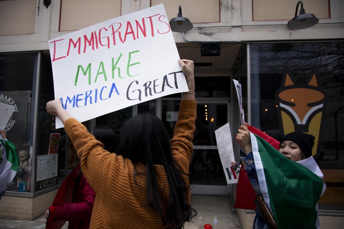 Protesters march down Main Street holding up signs on Sunday, Jan. 26, 2025, in downtown Lexington, Kentucky. Photo by Christian Kantosky | Assistant Photo Editor