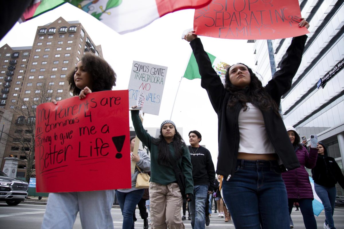 Protesters march down Main Street holding up signs and flags on Sunday, Jan. 26, 2025, in downtown Lexington, Kentucky. Photo by Christian Kantosky | Assistant Photo Editor