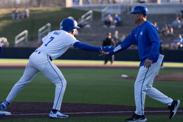 Kentucky Wildcats catcher Devin Burkes (7) daps up head coach Nick Mangione after stealing third base during the baseball game vs. Evansville on Tuesday, Feb. 25, 2025, at Kentucky Proud Park in Lexington, Kentucky. Kentucky 24-3 Photo by Greysun Niehaus | Staff