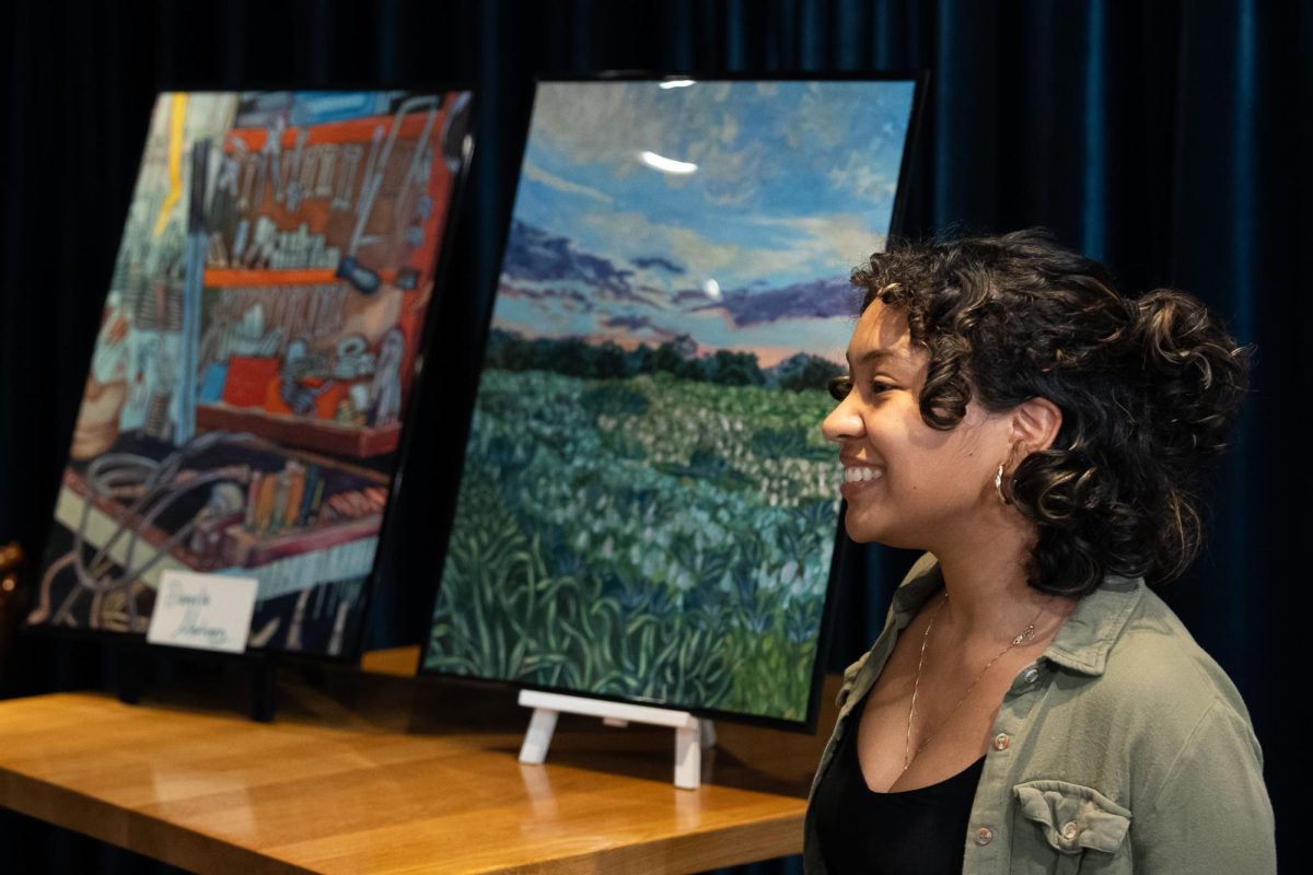 Daniella Martinez, a Sophomore majoring in architecture, presents her artwork during the Black Art Gala on Monday, Feb. 17, 2025, at the Gatton Student Center in Lexington, Kentucky.  Photo by Jack Stamats | Staff