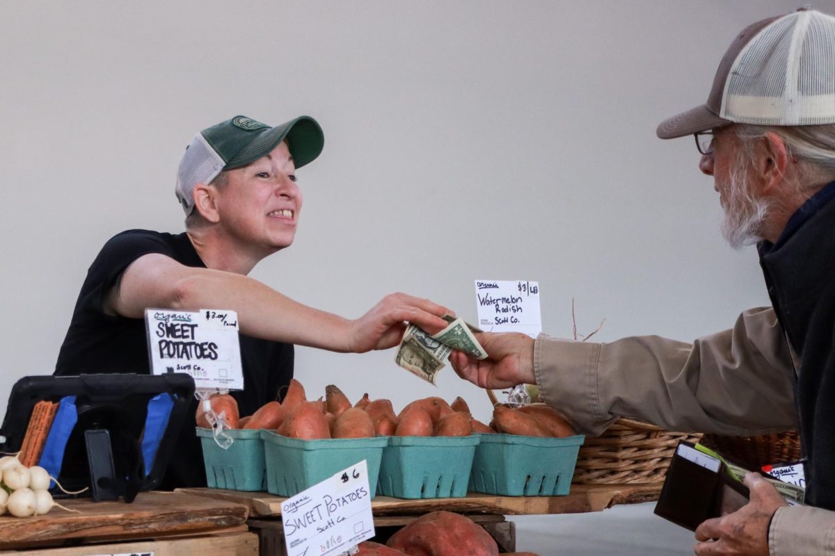 Elmwood Stock Farm worker Erin Parete makes a transaction during the Lexington Farmers Market at Greyline Station on Saturday March 8, 2025 in Lexington, Kentucky. Photo by Cara Raiford | Staff