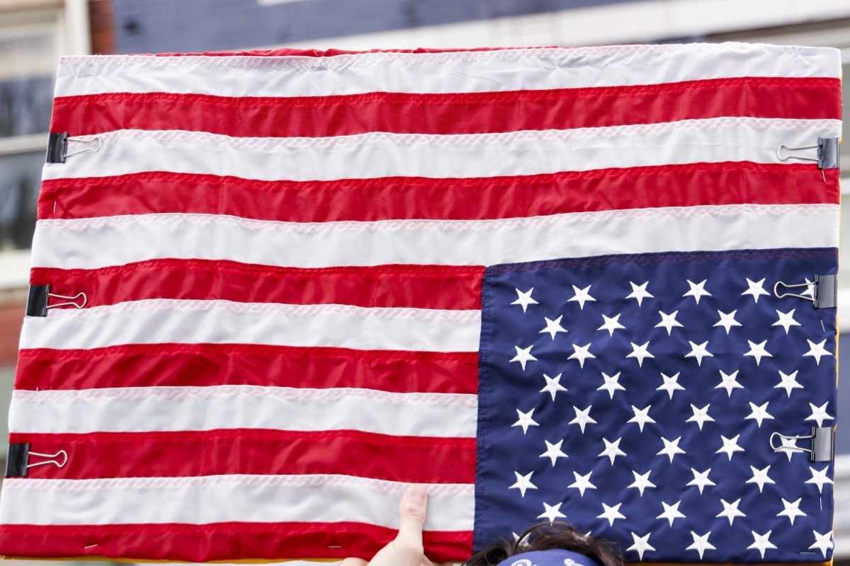 A protester holds an upside down flag during the “Hands Off!” protest on Saturday, April. 5, 2025, at Robert F. Stephens Courthouse Plaza in Lexington, KY Photo by Matthew Mueller | Photo Editor