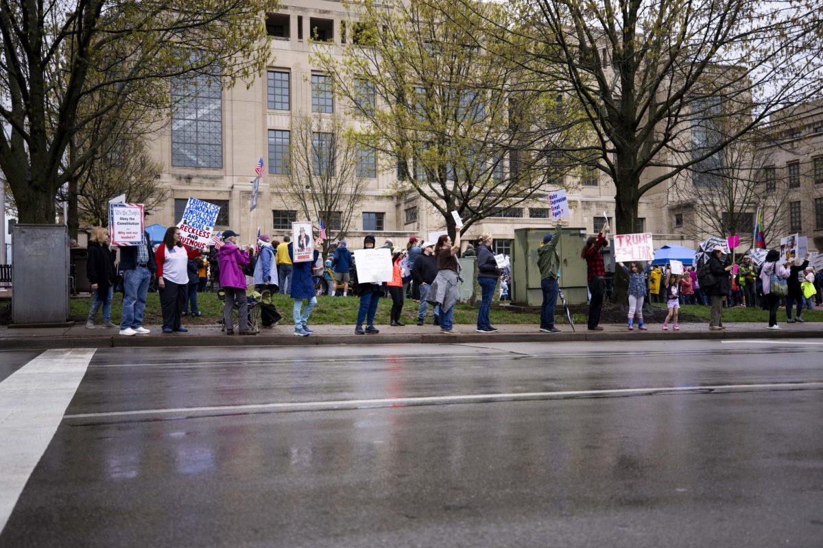 Protesters stand on the conner of a street with signs during the “Hands Off!” protest on Saturday, April. 5, 2025, at Robert F. Stephens Courthouse Plaza in Lexington, Ky Photo by Matthew Mueller | Photo Editor