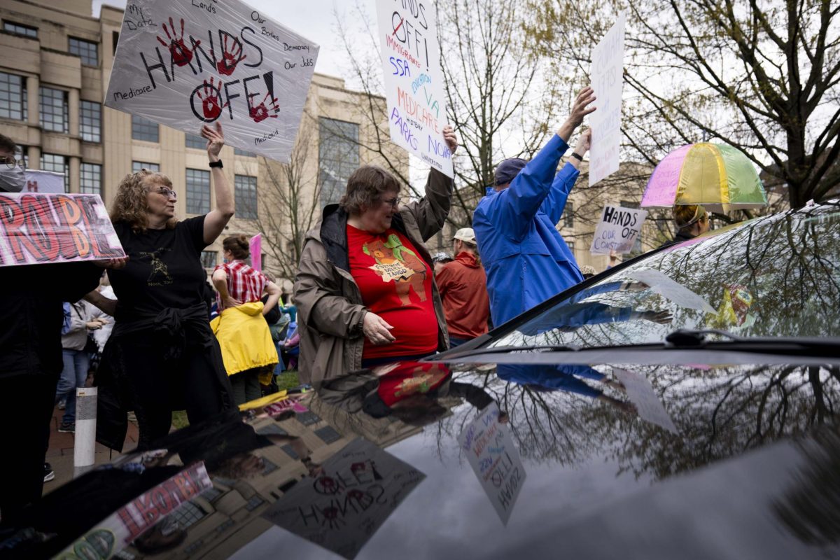 Protesters stand on the conner of a street with signs during the “Hands Off!” protest on Saturday, April. 5, 2025, at Robert F. Stephens Courthouse Plaza in Lexington, Ky Photo by Matthew Mueller | Photo Editor