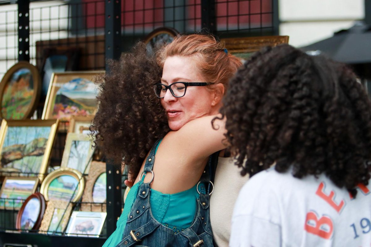 Shop owner Jennifer Millard hugs one of her customers during the Art on the Town on Thursday, April 10, 2025, at Tandy Park in Lexington, Ky. Photo by Cara Raiford | Staff