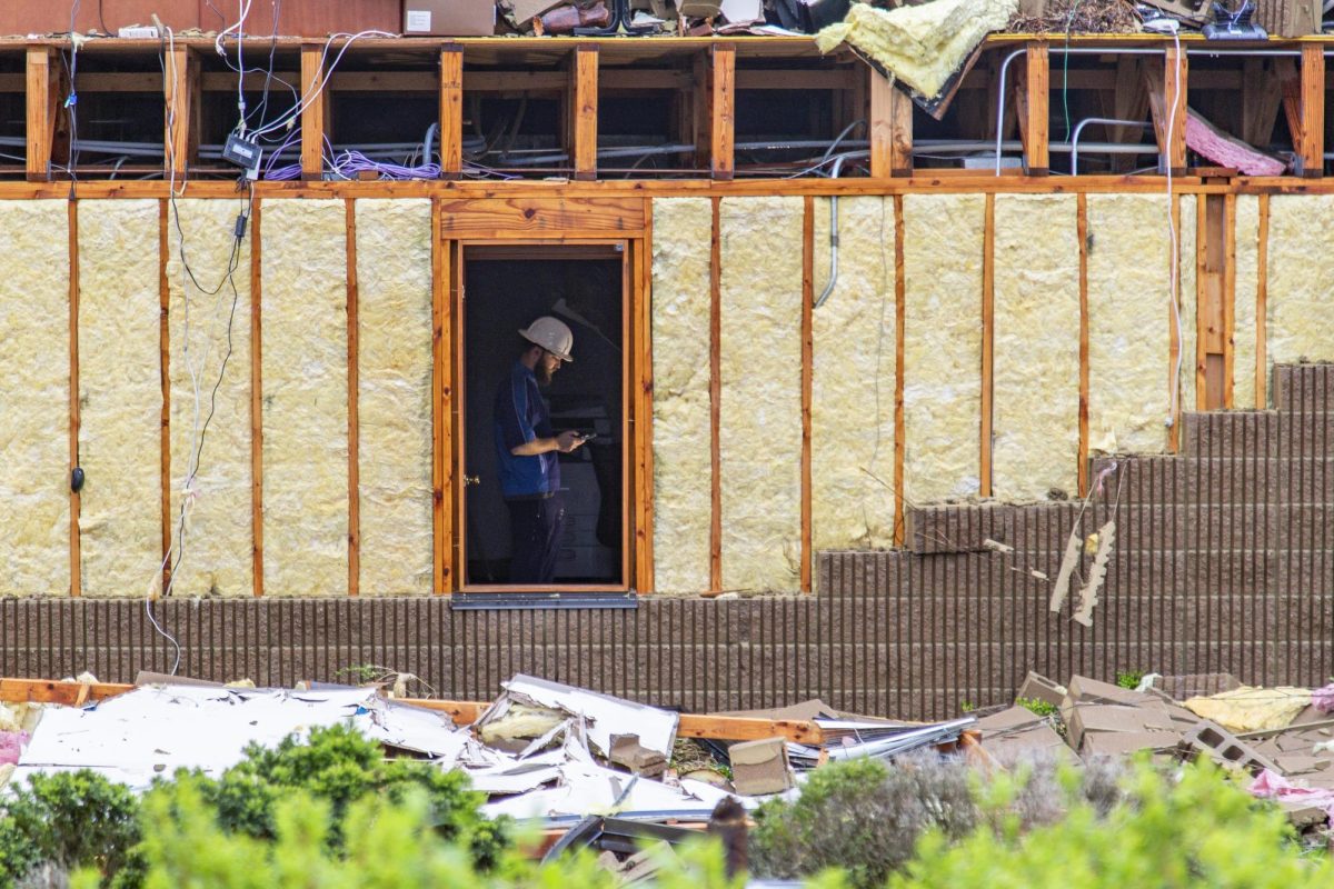 A volunteer helping cleanup tornado damage, takes a break from work on Friday, April 4, 2025, at Jeffersontown in Louisville, Ky. Photo by Christian Kantosky | Assistant Photo Editor