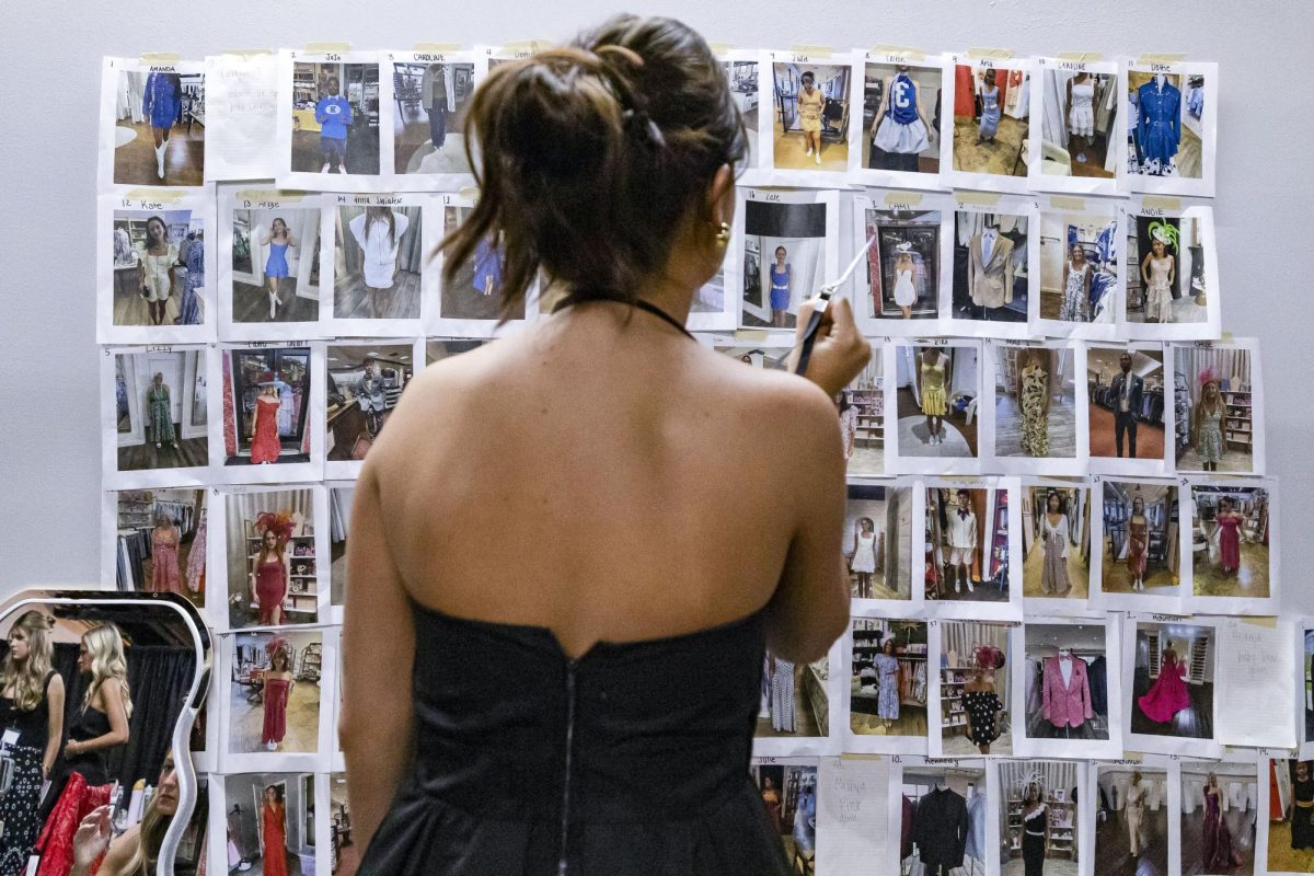 A student worker looks at the wall during the Color Me Kentucky fashion show organized and led by students in the Department of Retailing and Tourism Management on Monday, March 17, 2025, at The Manchester Reserve in Lexington, Kentucky. Photo by Sydney Novack | Staff