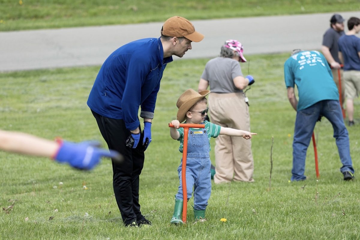 Ben Costigna and his son dig a hole with a dibble bar during Reforest the Bluegrass, a community tree planting festival at Jacobson Park on Saturday, April 19, 2025 in Lexington, Kentucky. Photo by Casey Sebastiano | Staff
