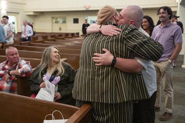 Jay Stringer-Vaught, surround by their family, is kissed by their husband after the Community Commencement on Friday, May 2, 2025, at Maxwell Street Presbyterian Church in Lexington, Ky. Photo by Christian Kantosky | Assistant Photo Editor