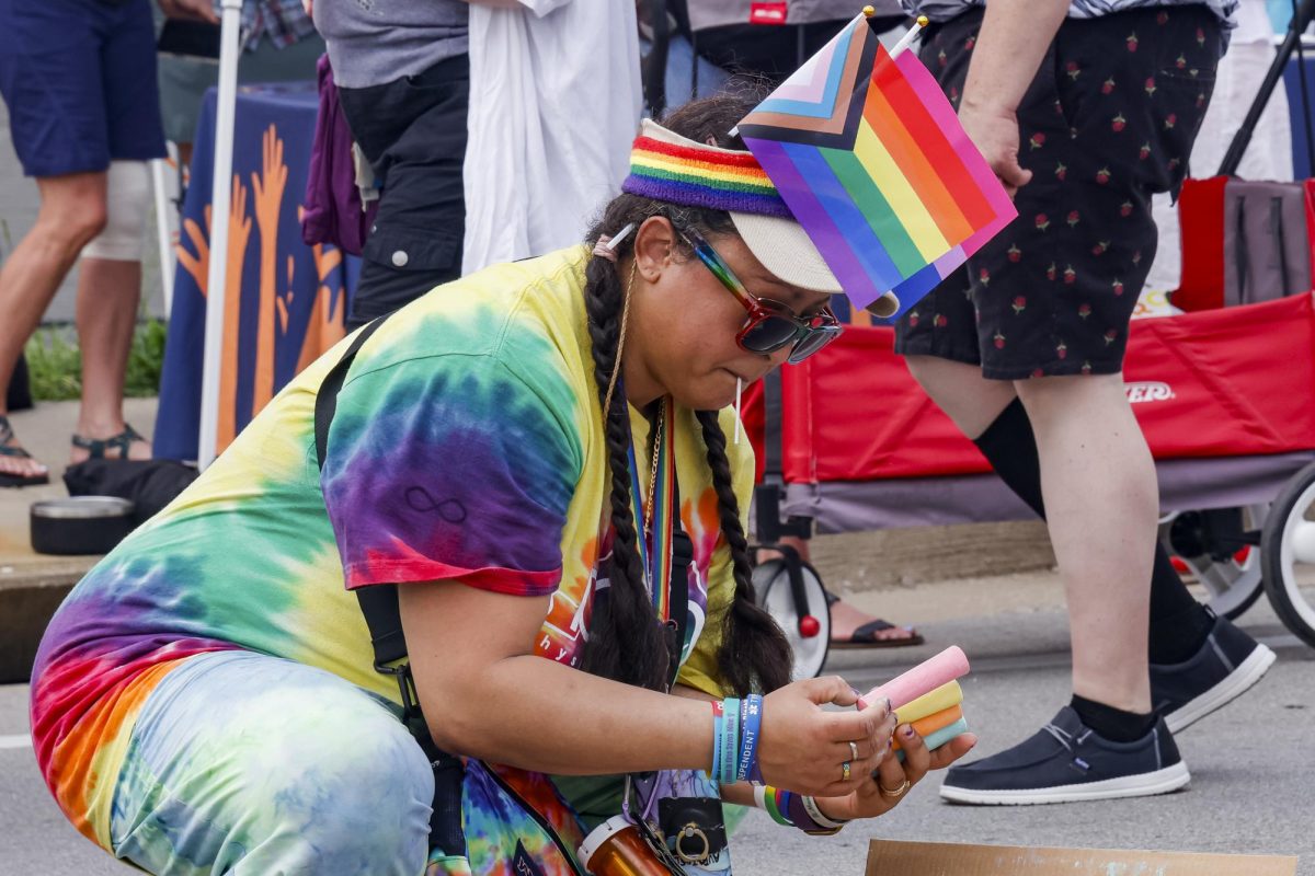 A Lexington Pride Festival attendee sorts through a colorful array of sidewalk chalk to draw on the road with in Lexington, Kentucky on Saturday, June 28, 2025. Photo by Hannah Piedad | Staff