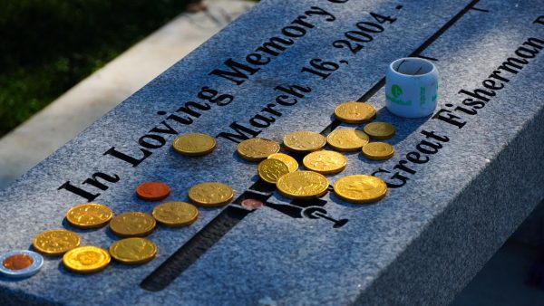 Chocolate coins are scattered across the left side of the memorial bench on Monday, March 17, 2025, in Crestview Hills, Kentucky. Photo by Ava Bumgarner