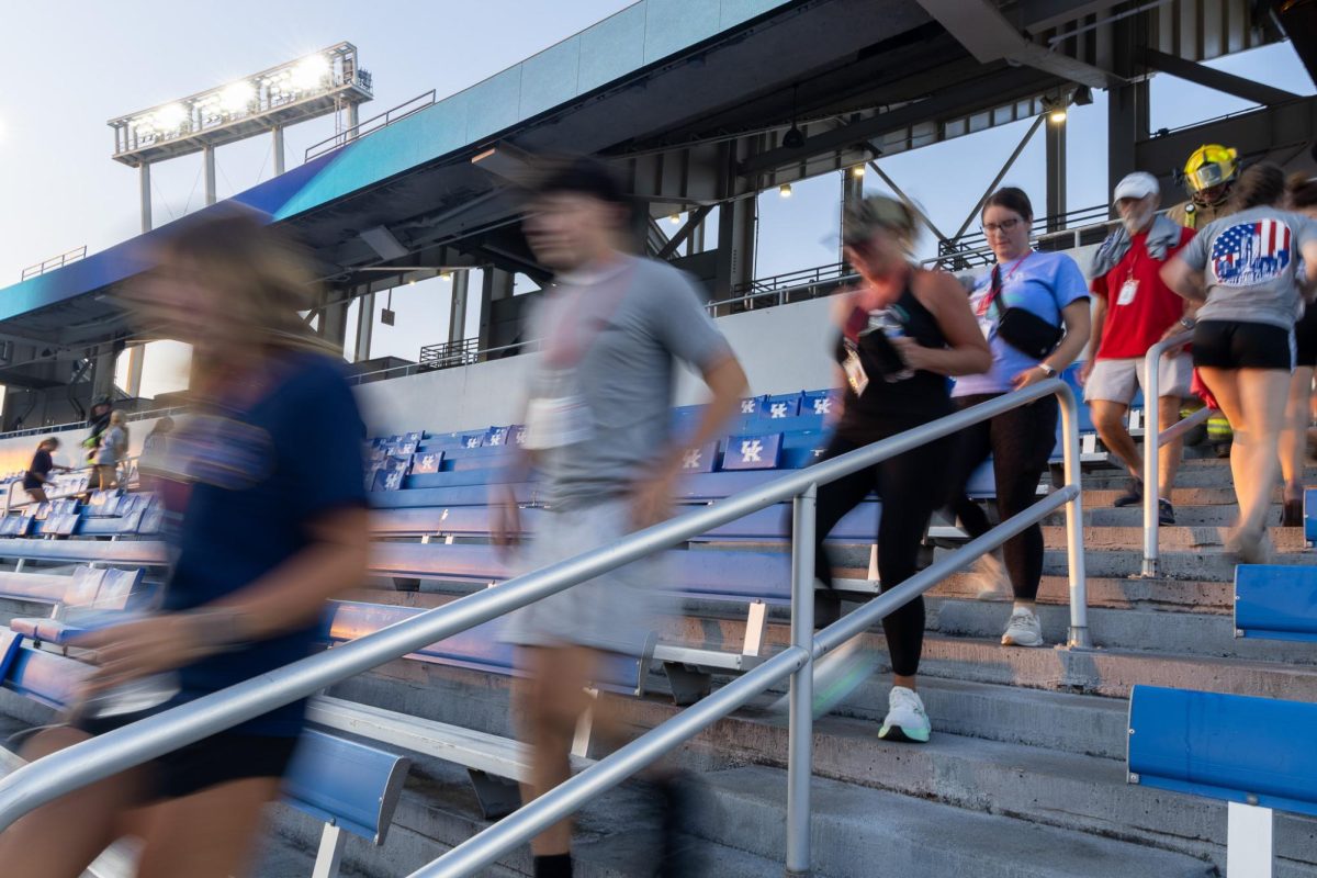 Kristen Kuveikis, left, and her son Aiden Hall, center, walk down stairs of the lower bowl during the 9/11 Stair Climb on Thursday, Sept. 11, 2025, at Kroger Field in Lexington, Ky. Photo by Isabella Sepahban | Staff