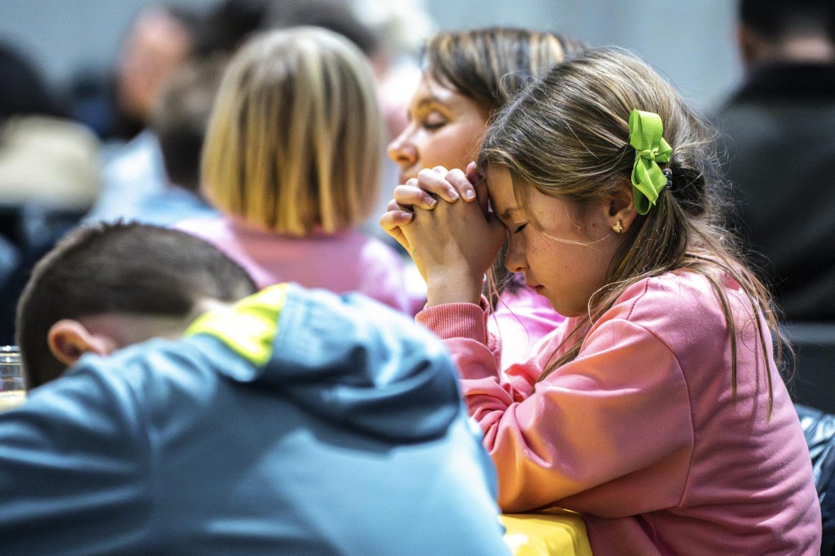 A girl prays before eating during the International Thanksgiving Dinner on Saturday, Nov. 22, 2025, at Ashland Avenue Baptist Church in Lexington, Ky. Photo by Will Luckett | Staff